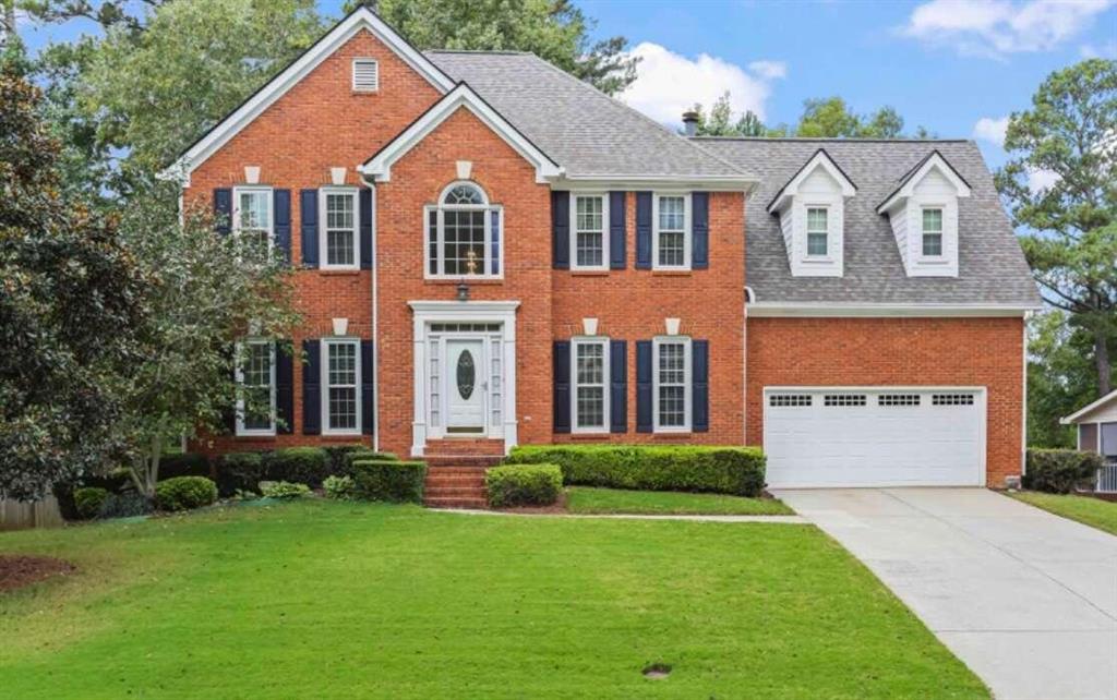 a front view of a house with a yard and garage