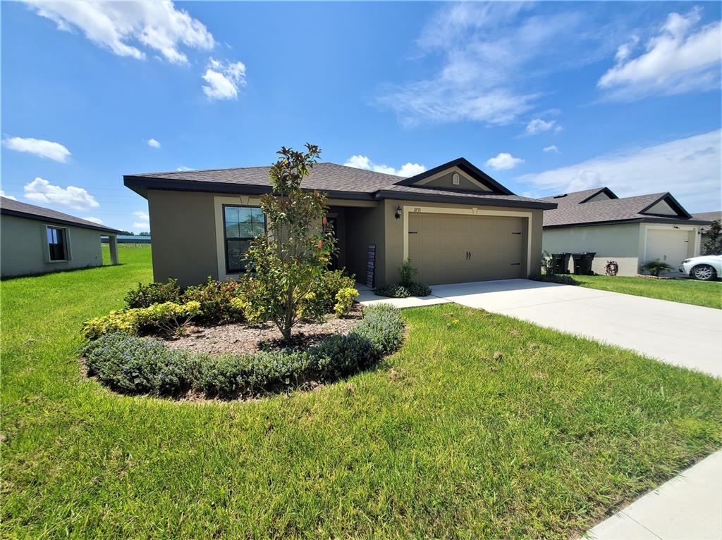 a front view of a house with a yard and garage