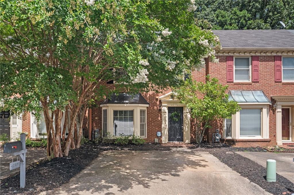 front view of a house with a tree in front of it