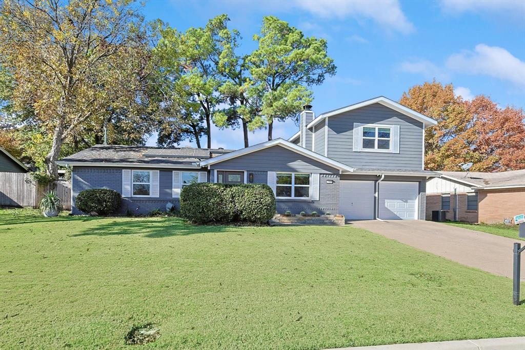 View of front of property featuring a front yard, a garage, and central AC unit