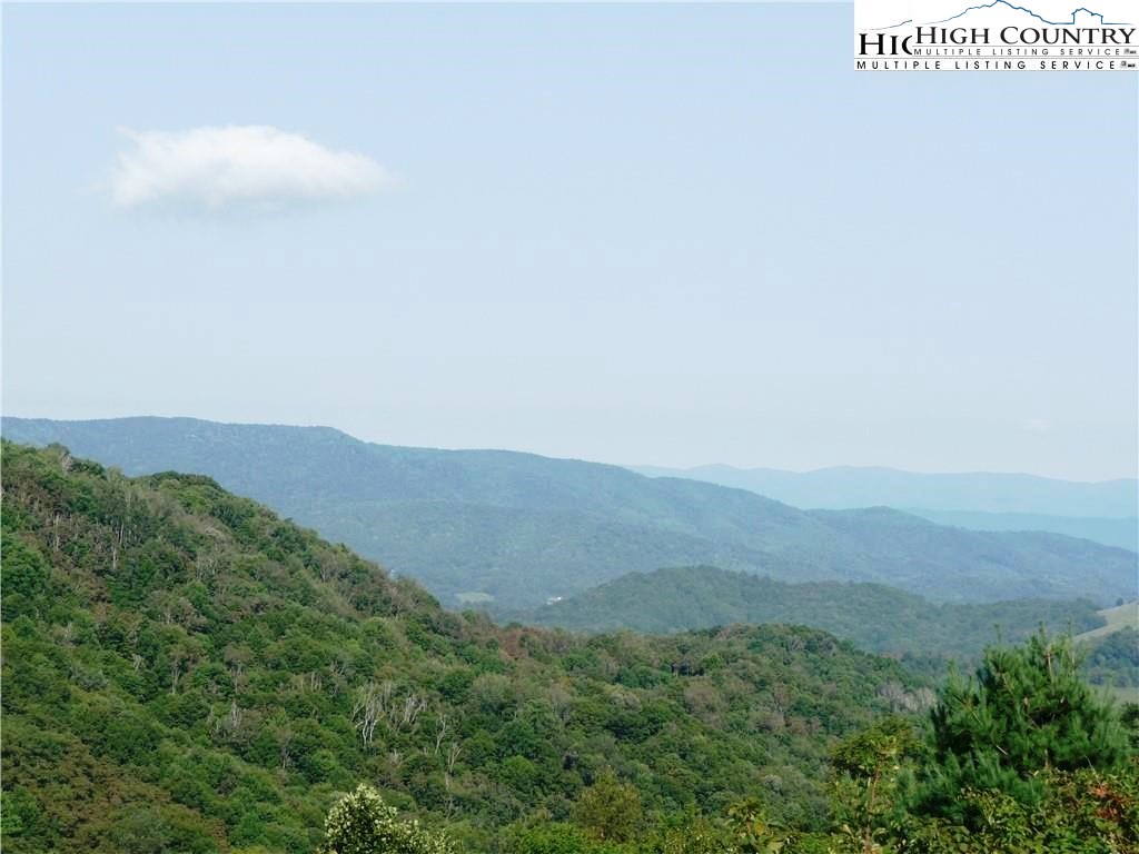 a view of a field with mountains in the background