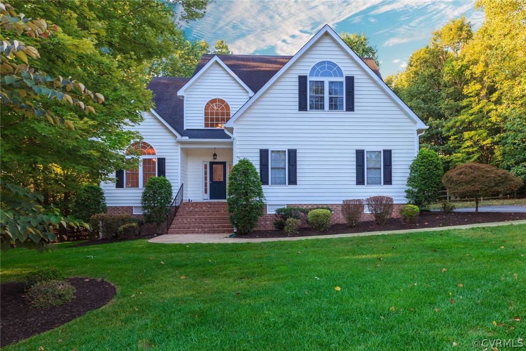 a front view of a house with a yard and green space