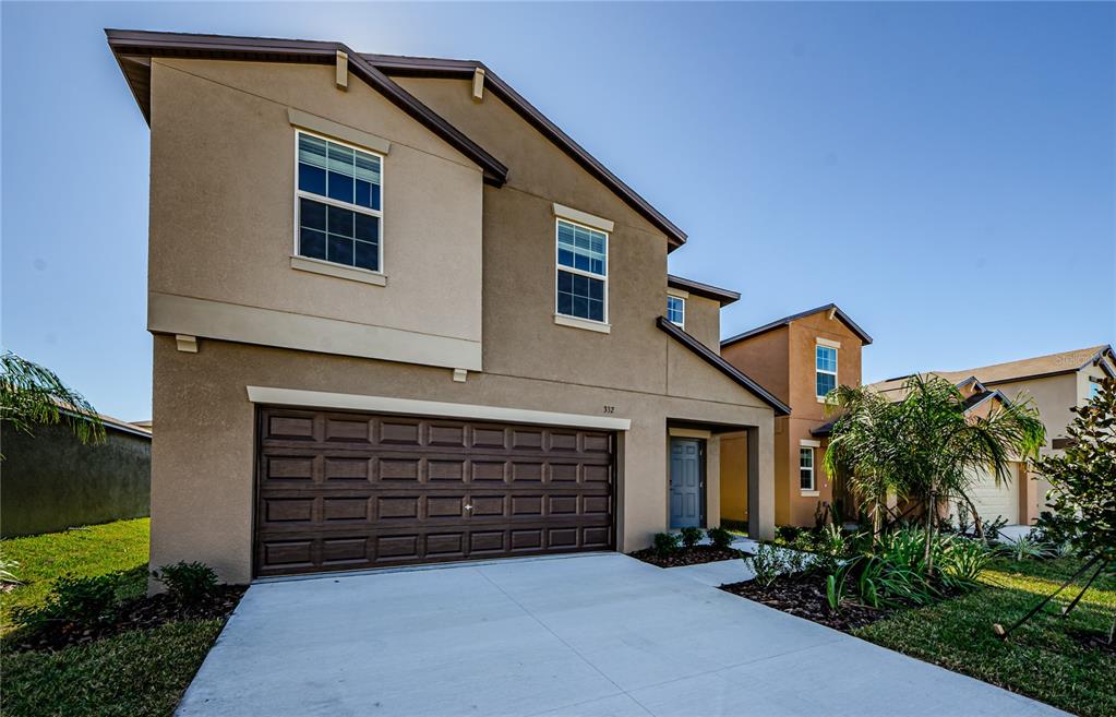 a front view of a house with a yard and garage