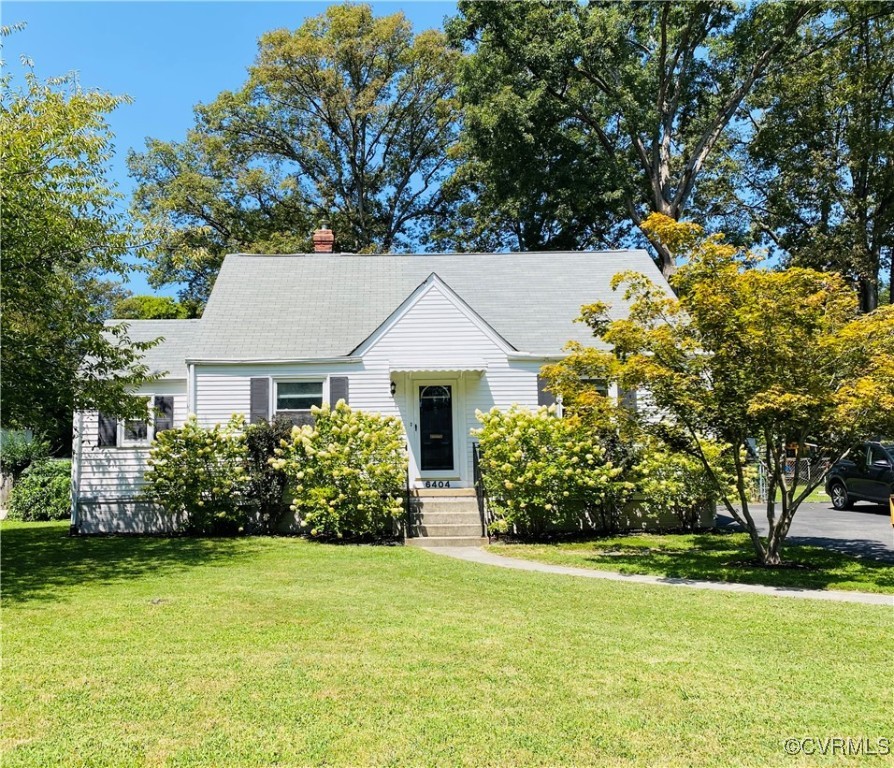 front view of house with a yard and potted plants