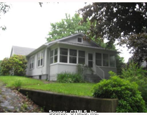 a front view of a house with a yard and potted plants