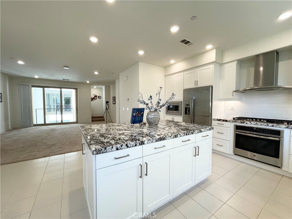 a kitchen with stainless steel appliances kitchen island granite countertop a stove and a sink