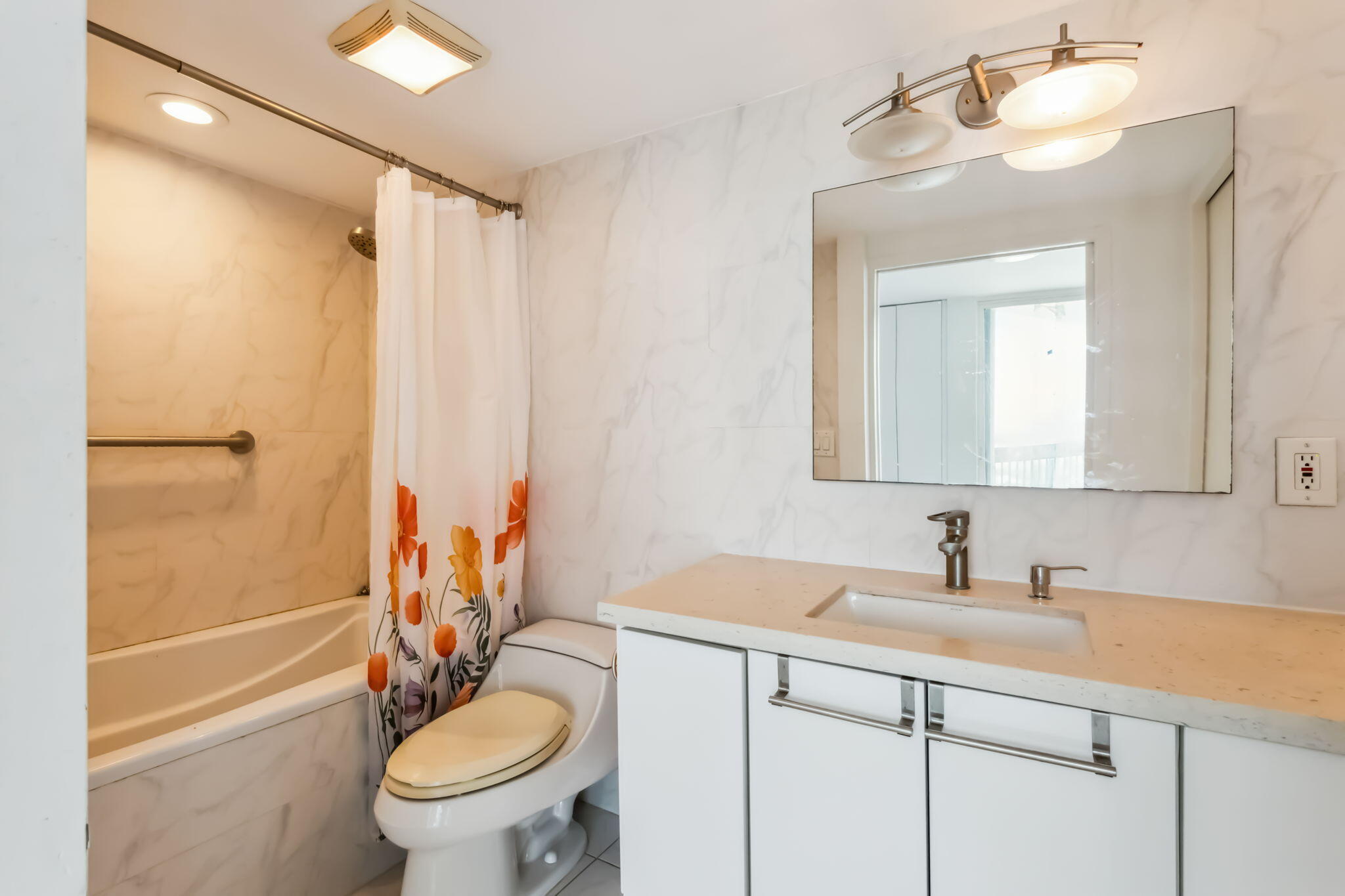 a bathroom with a granite countertop sink toilet and shower