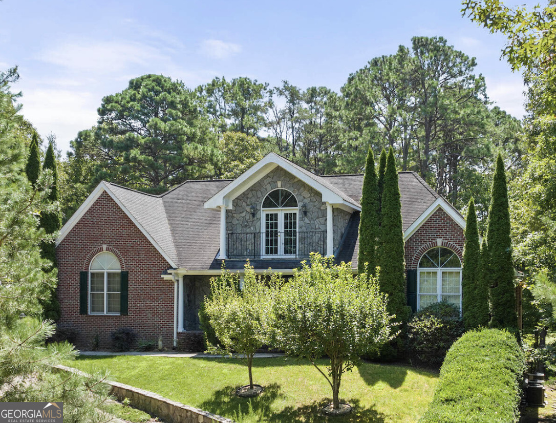 a front view of a house with a yard and potted plants