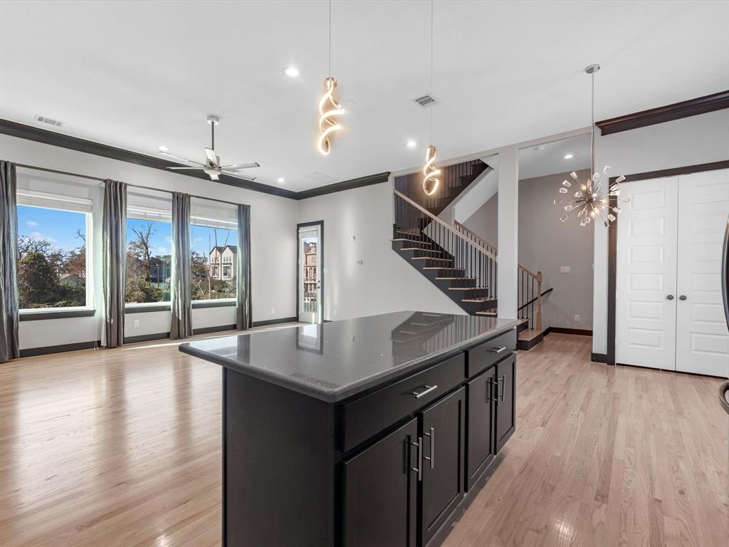 an open kitchen with wooden floor and outdoor space