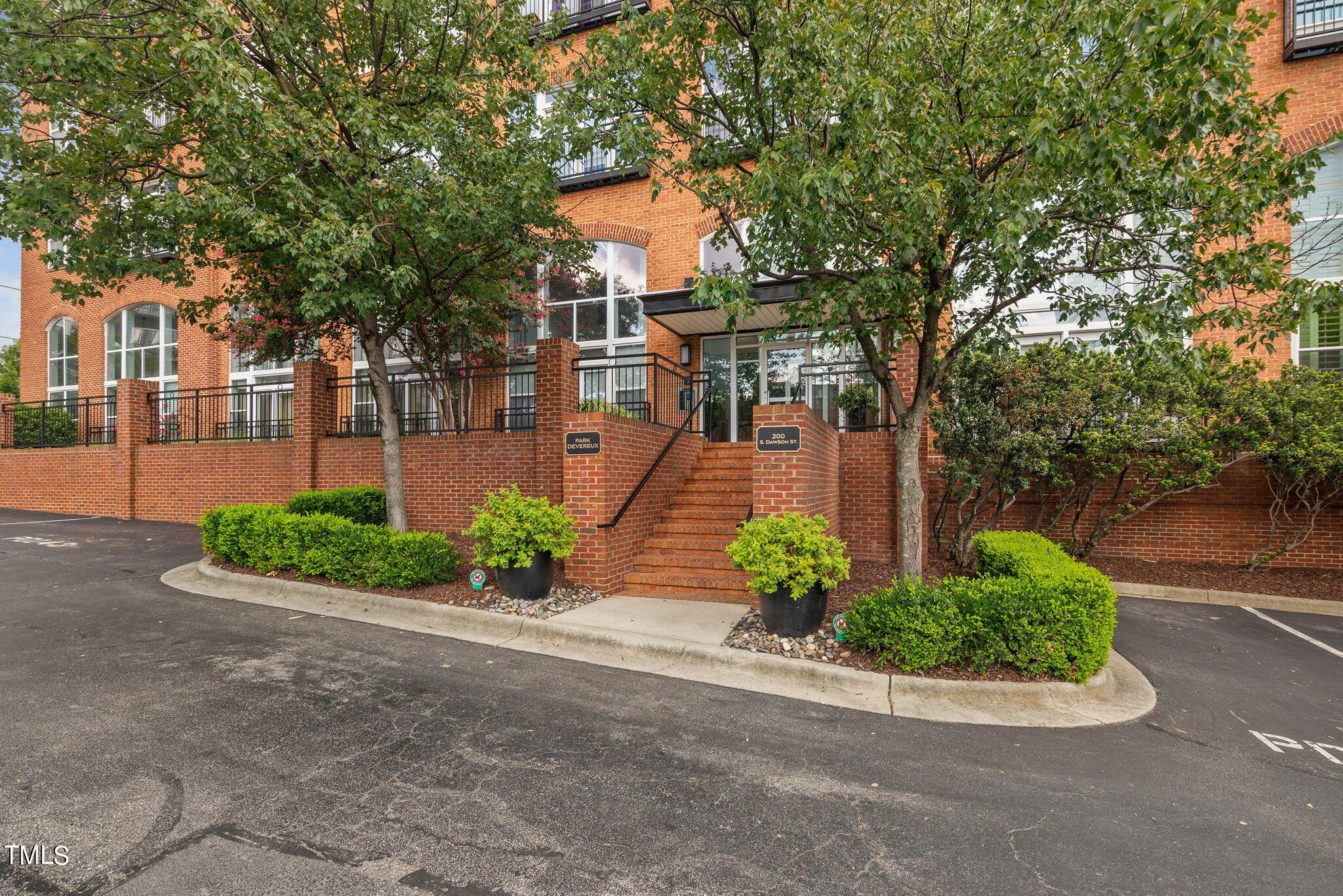 a front view of a house with a yard and potted plants