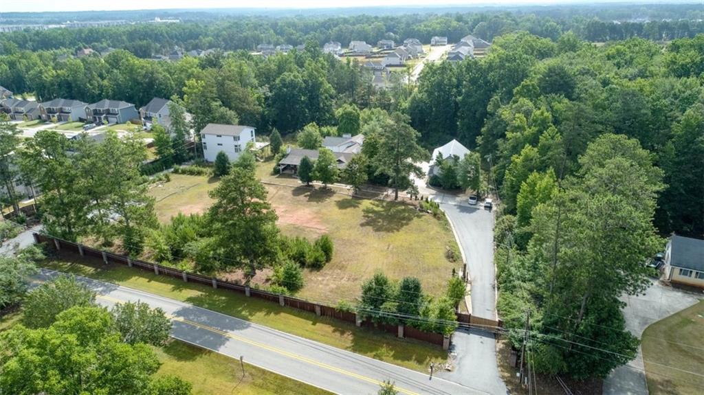 an aerial view of residential houses with outdoor space and trees