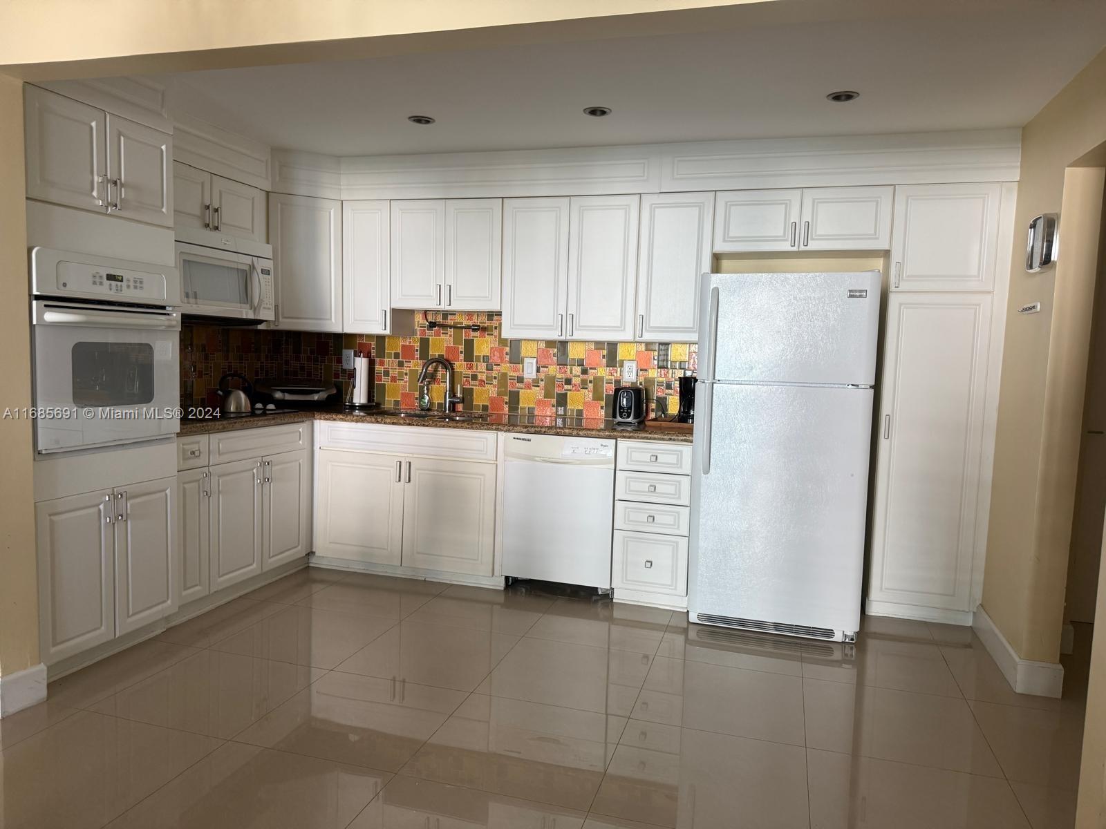 a kitchen with white cabinets and white stainless steel appliances