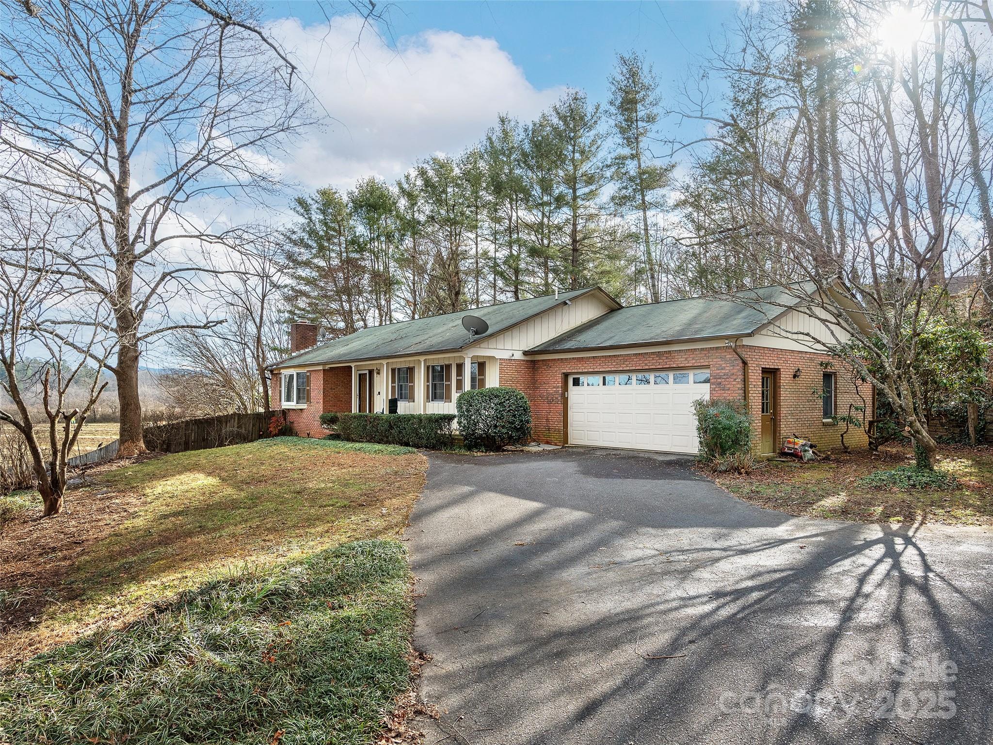 a front view of a house with a yard and trees