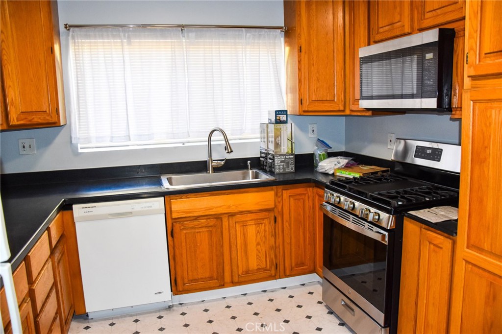 a kitchen with stainless steel appliances a stove a sink and a microwave