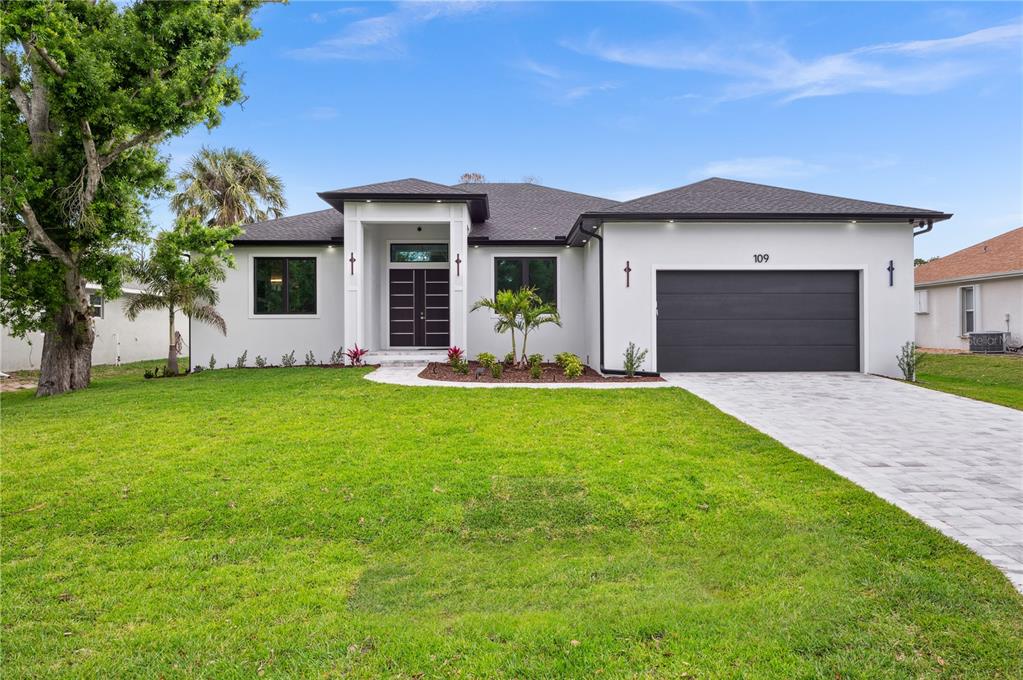 a front view of a house with a yard and garage