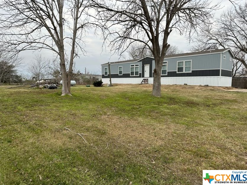 a view of a yard with a house and large trees