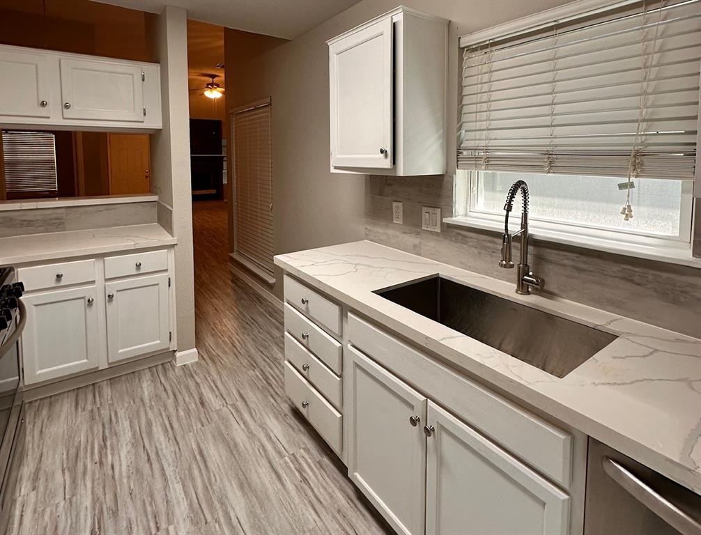 a kitchen with stainless steel appliances granite countertop a sink and wooden cabinets