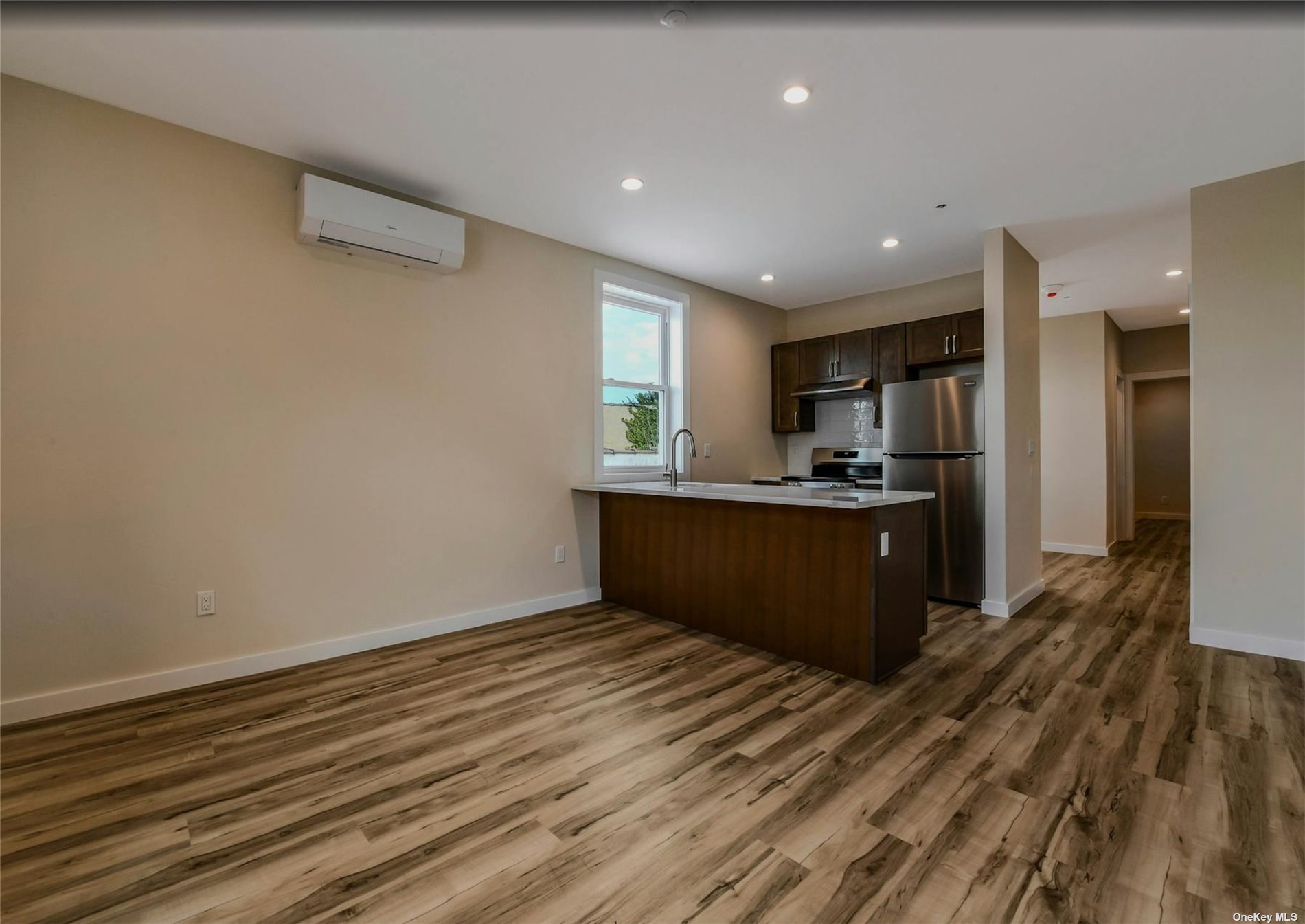 a kitchen with stainless steel appliances kitchen island granite countertop a refrigerator and a sink