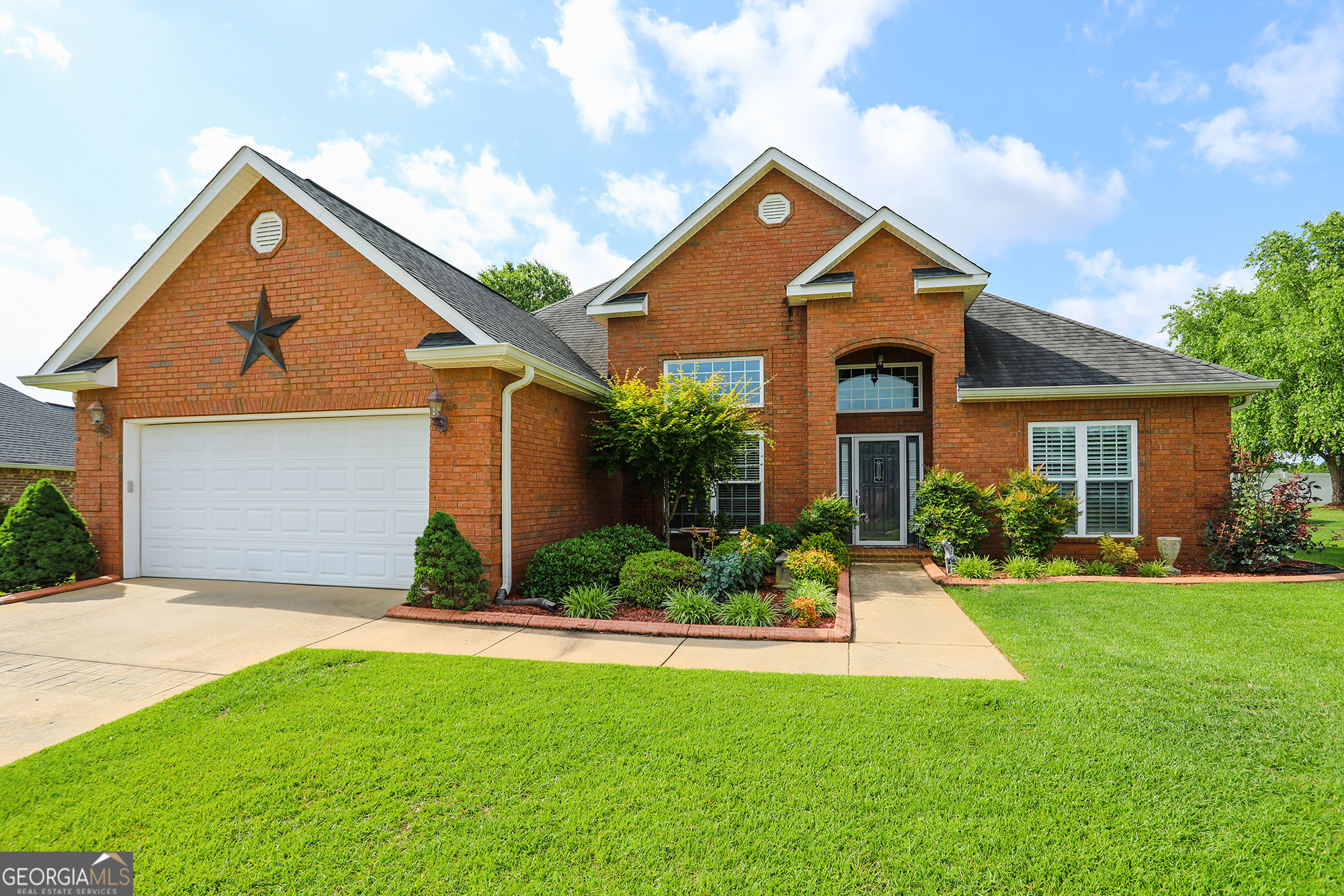 a front view of a house with a yard and garage