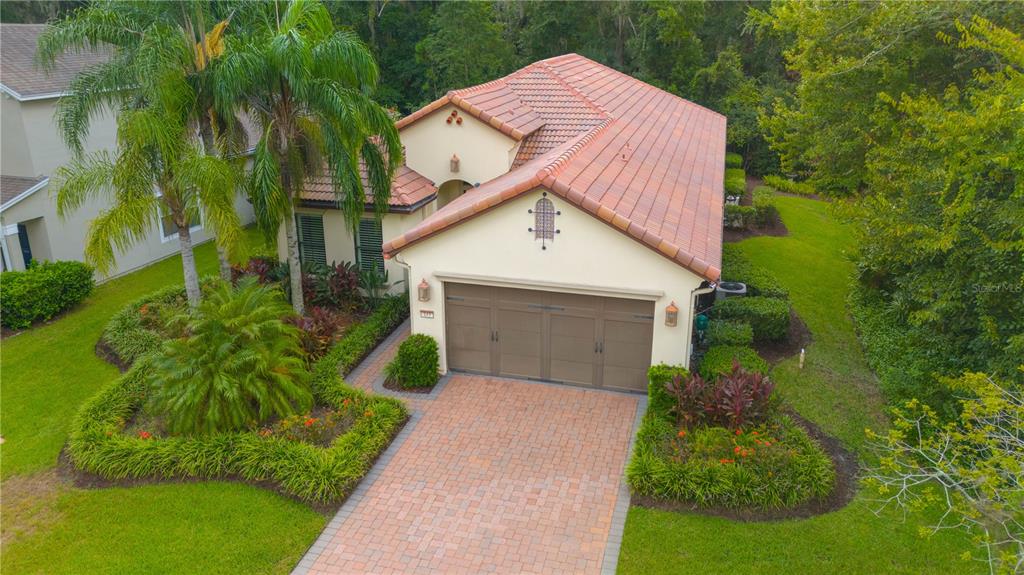 a aerial view of a house with a yard and potted plants