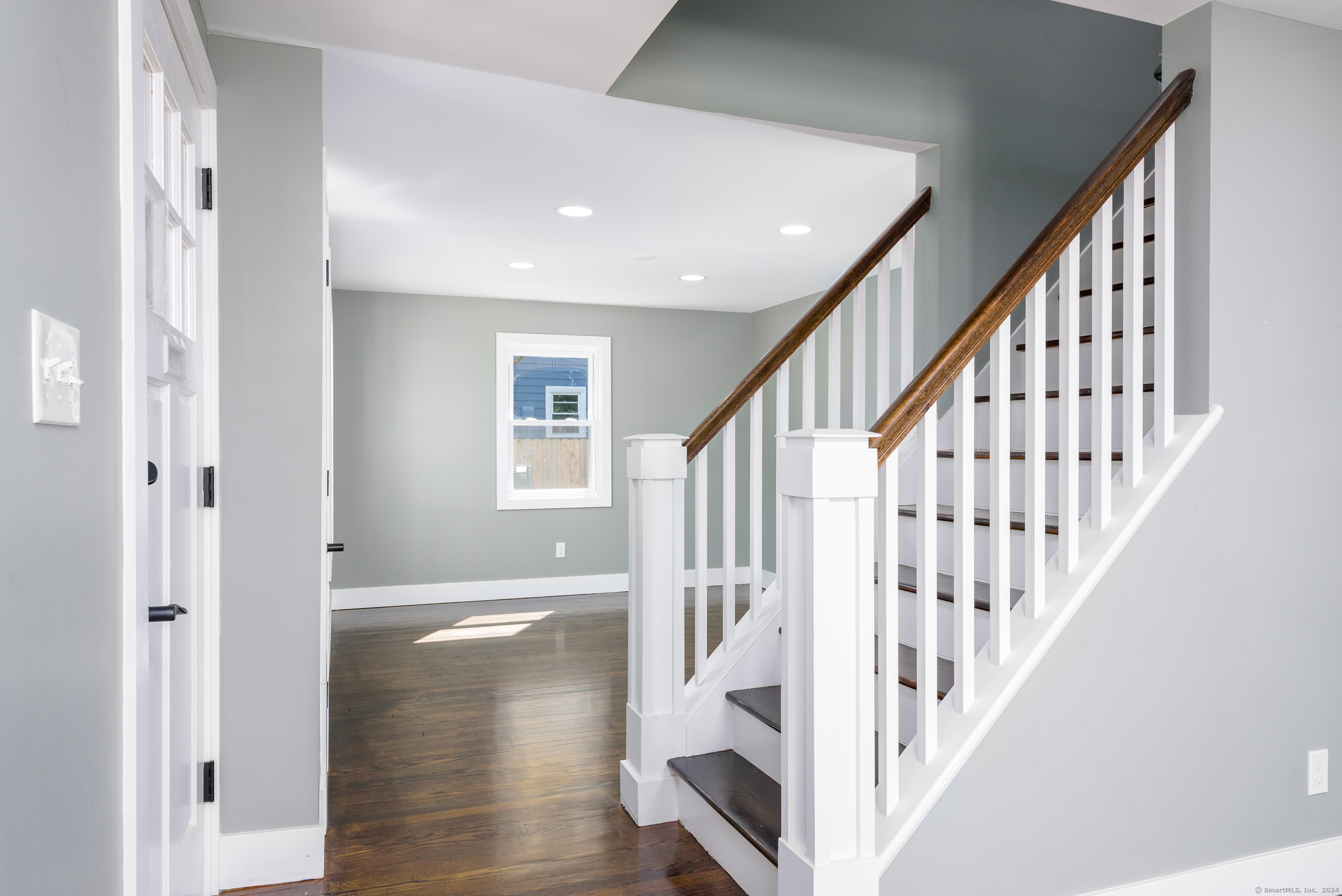 a view of staircase with lots of frames and a rug