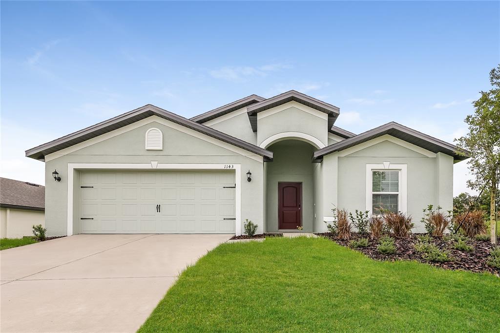 a view of a house with a yard and garage