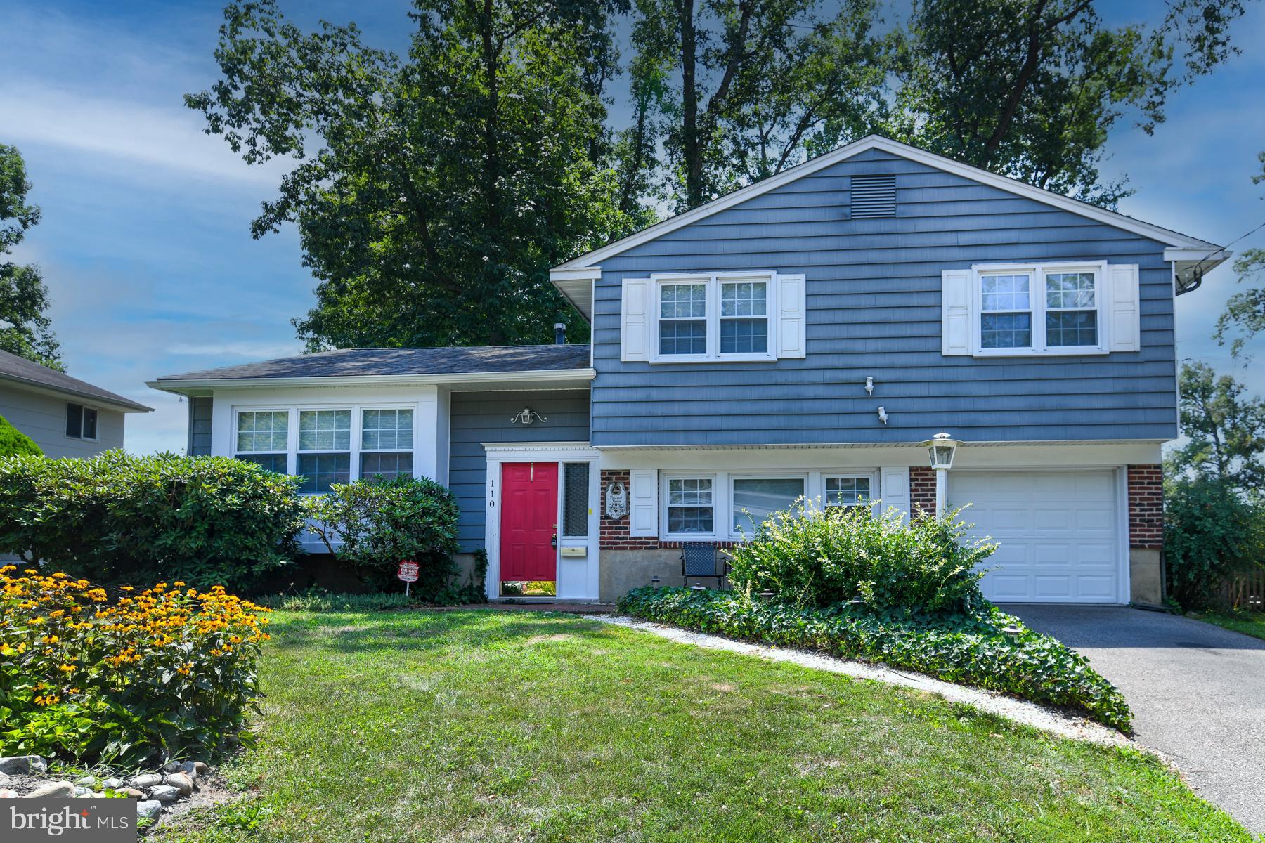 a front view of a house with a yard and plants