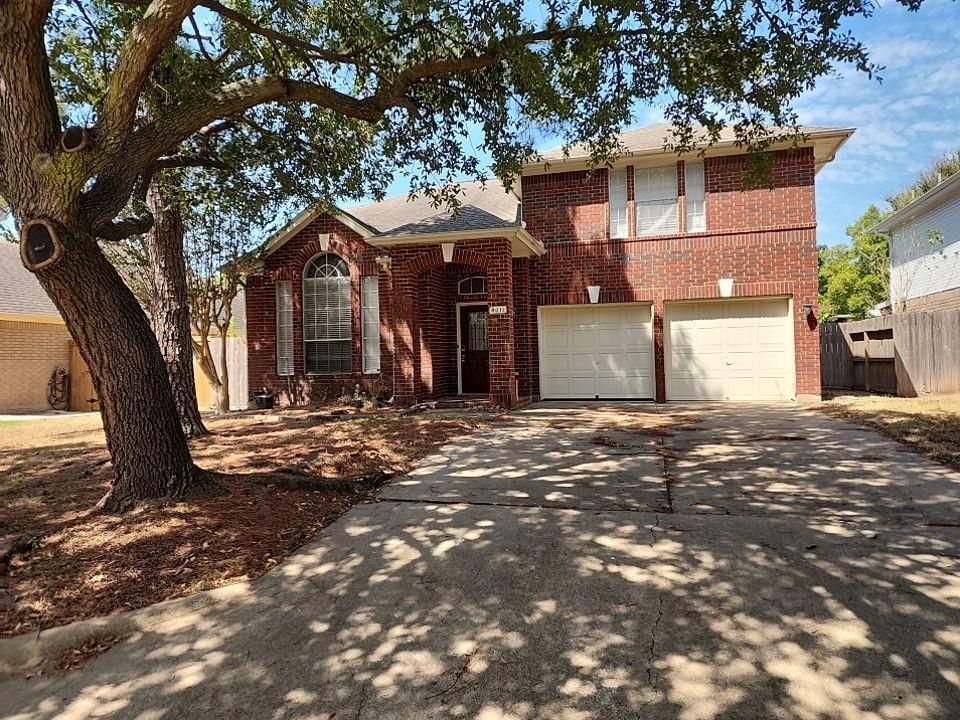 a front view of a house with a tree