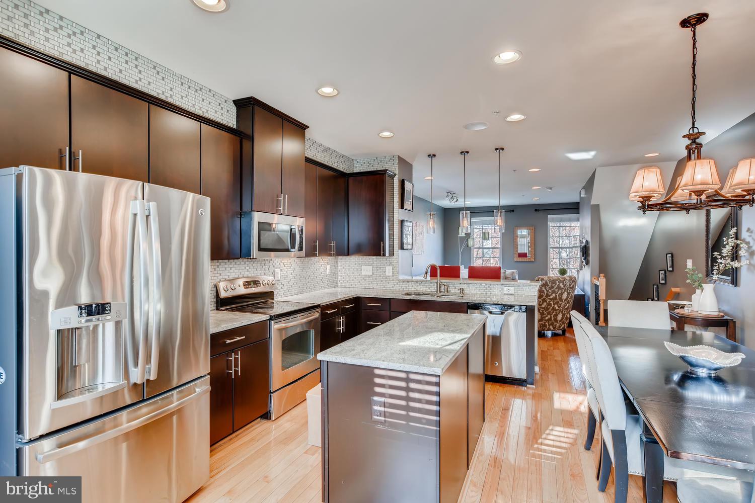 a kitchen with stainless steel appliances granite countertop a refrigerator stove microwave and sink