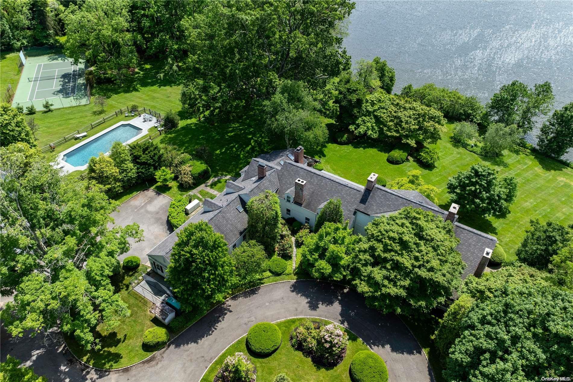 an aerial view of residential house with outdoor space and trees all around