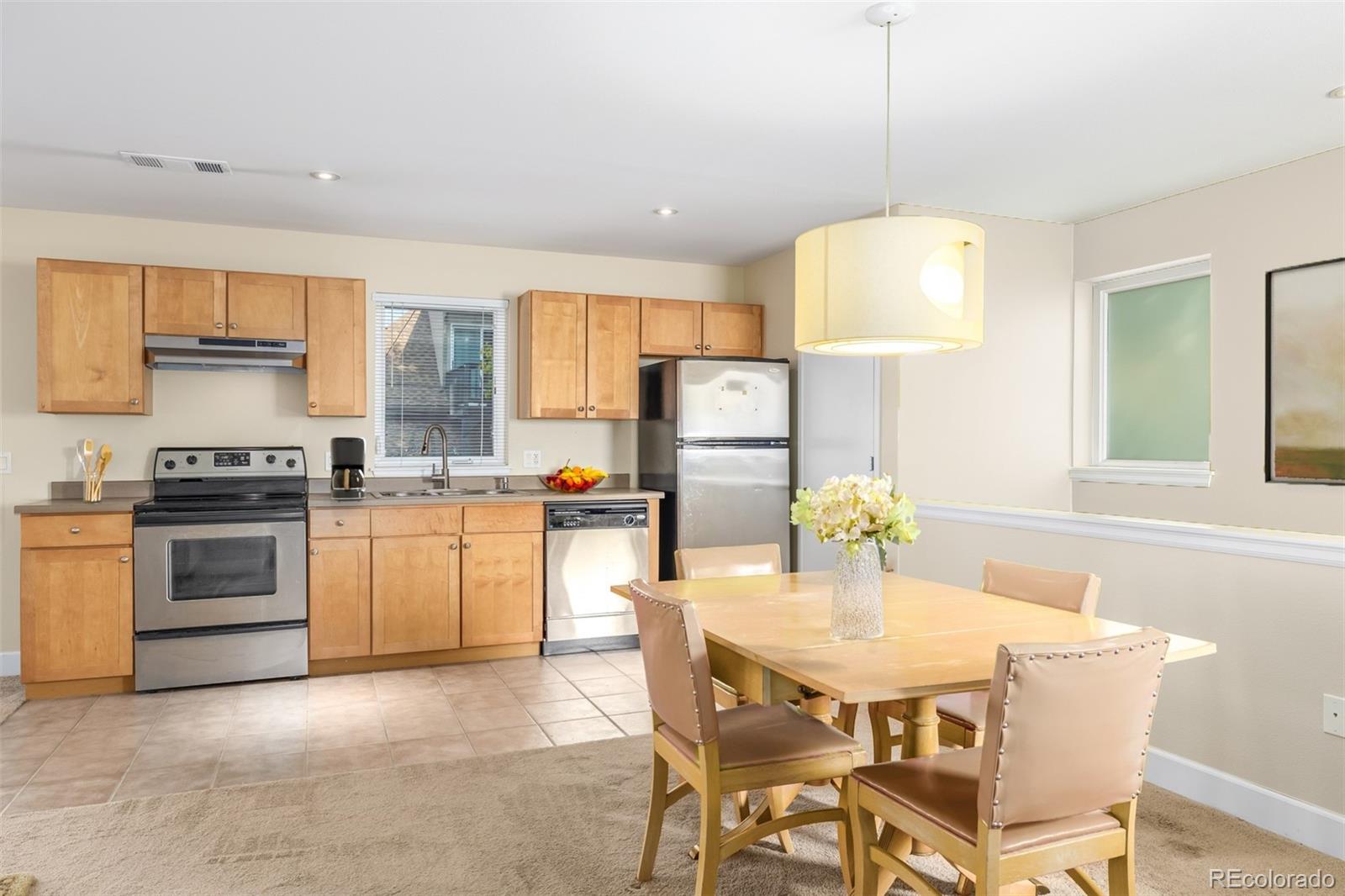 a kitchen with a dining table chairs and white cabinets