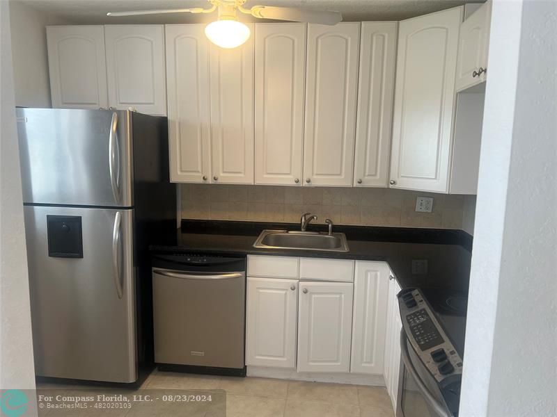 a kitchen with a refrigerator and a stove top oven