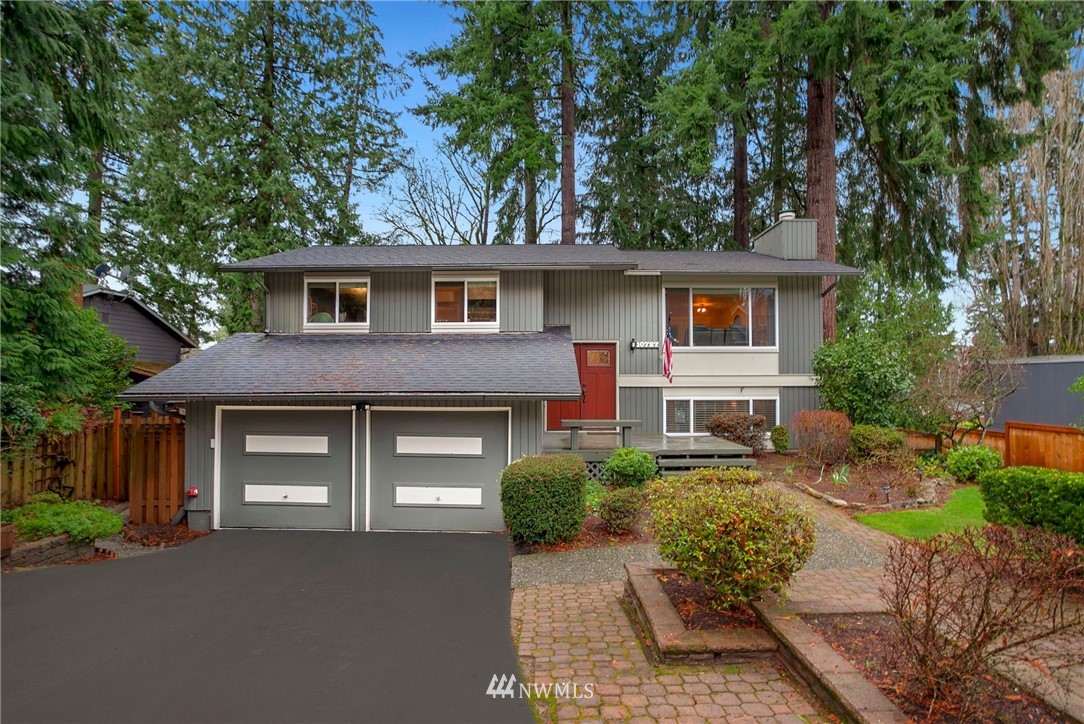 a front view of a house with a garden and trees