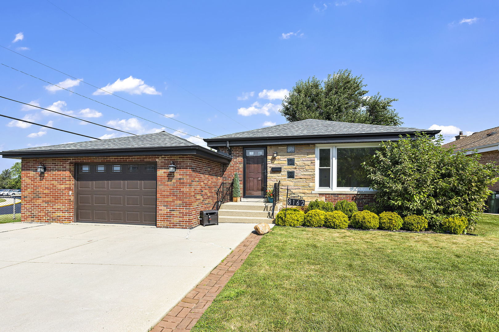 a front view of a house with a yard and potted plants