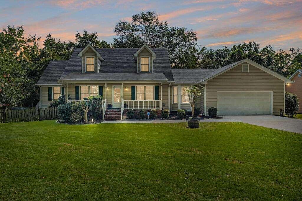 a front view of a house with a garden and yard