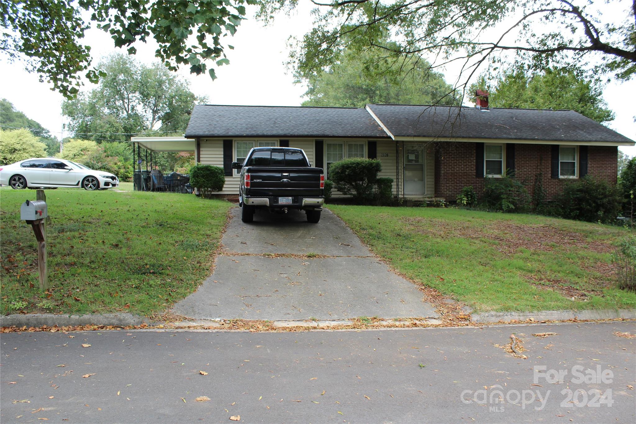 a front view of a house with a garden and trees