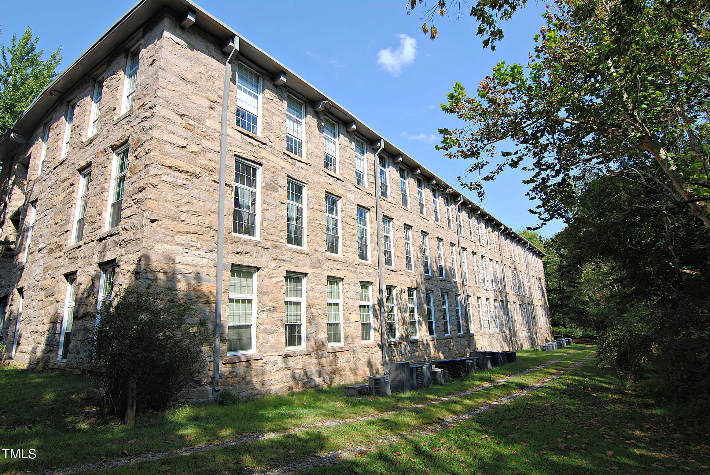 a large building with a big yard and more windows