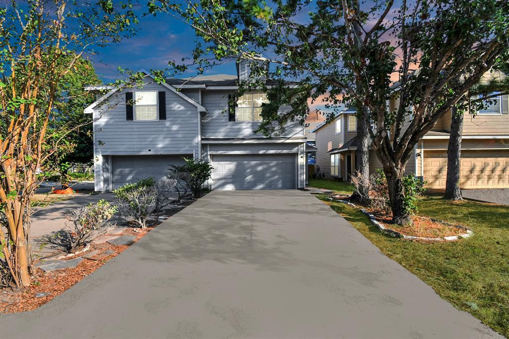 a front view of a house with a yard and tree s