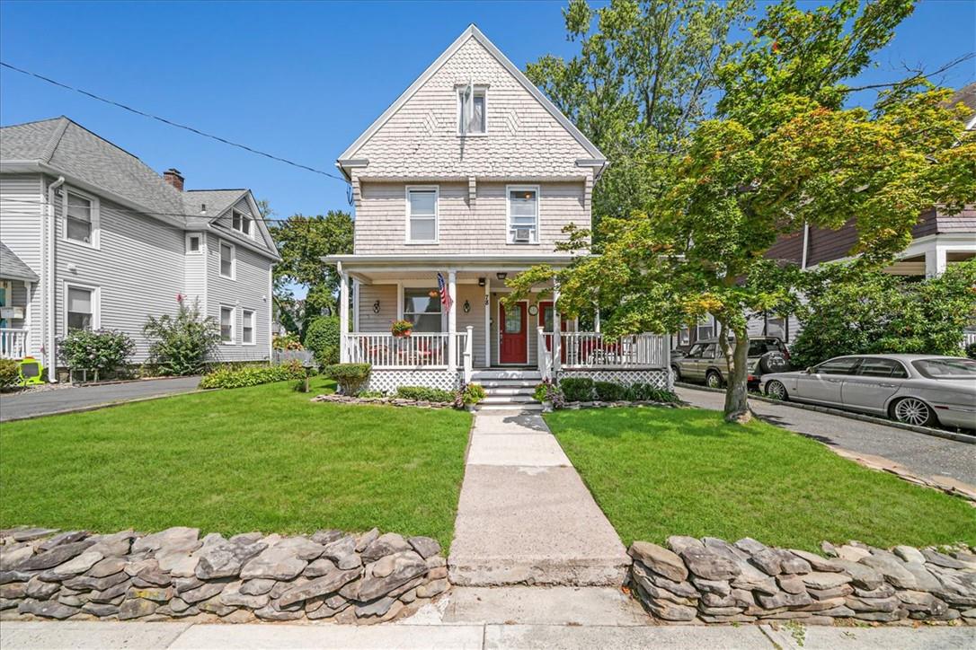 a front view of a house with a yard and potted plants