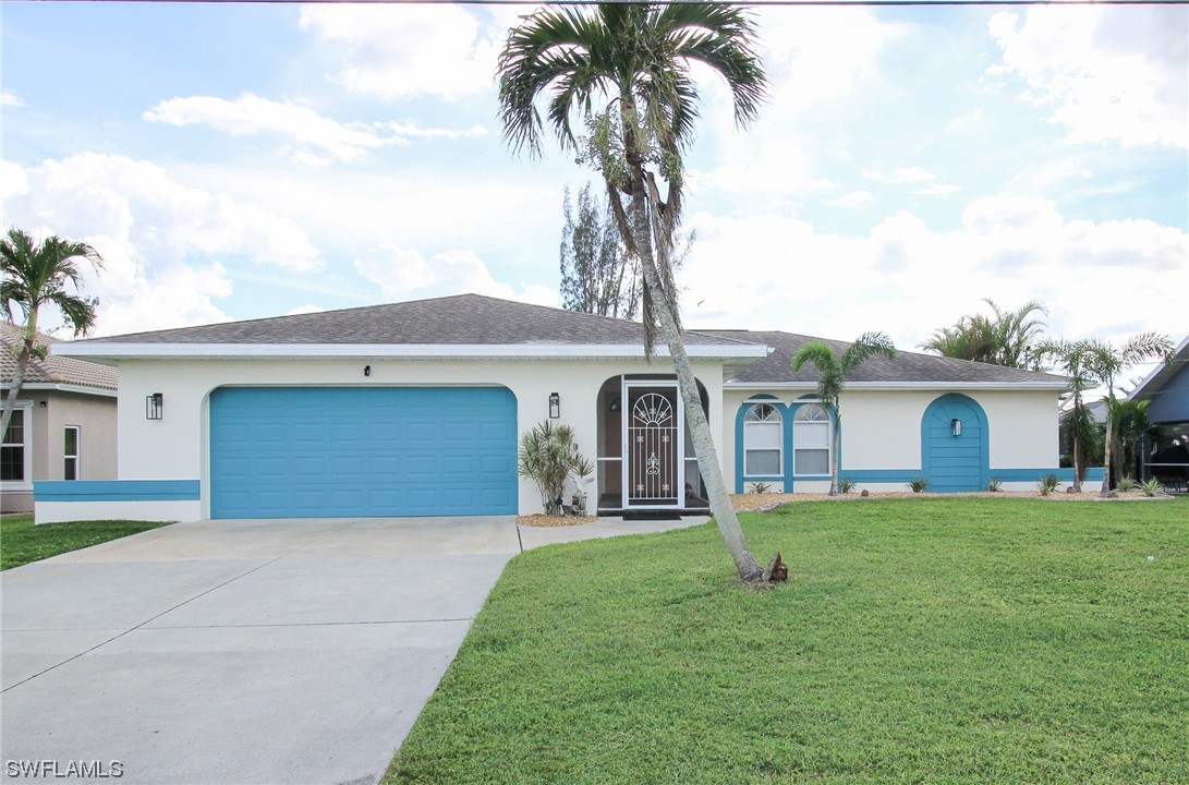 a front view of house with yard and garage