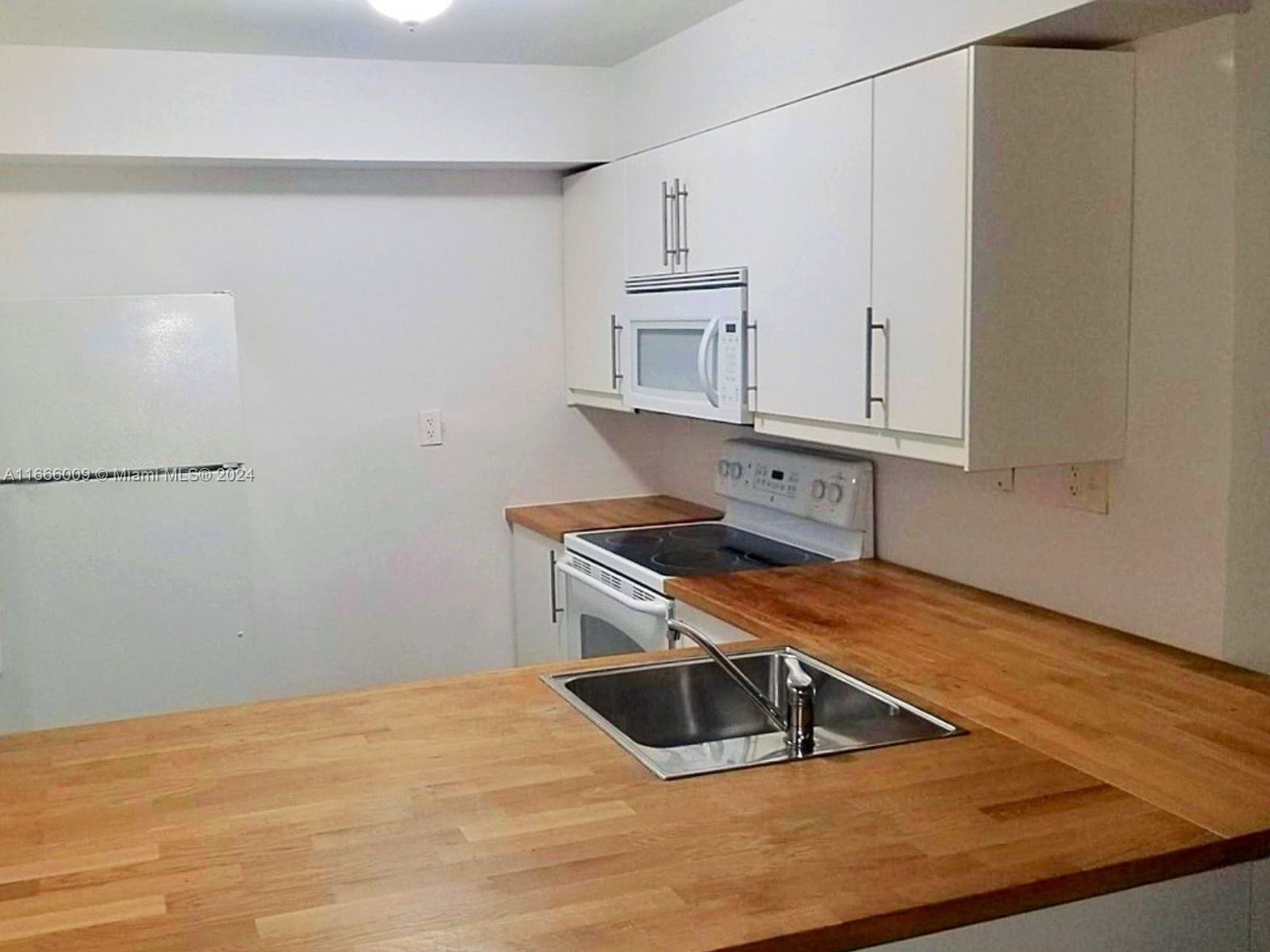 a kitchen with white cabinets and a sink