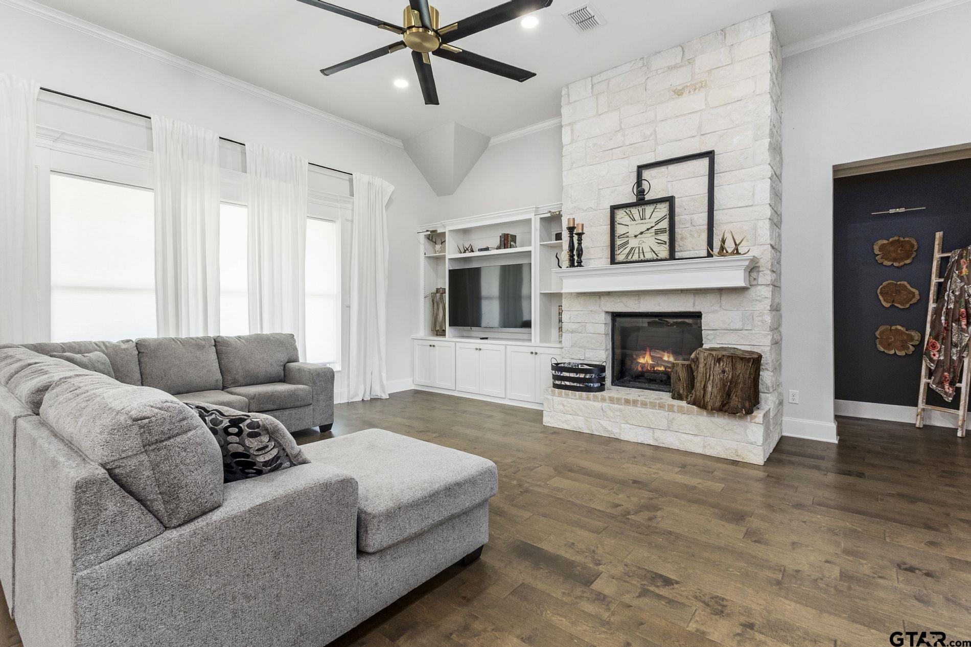 a living room with furniture a flat screen tv and a fireplace