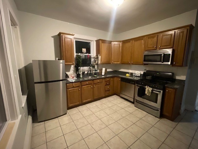 a kitchen with stainless steel appliances granite countertop a refrigerator stove top oven and sink