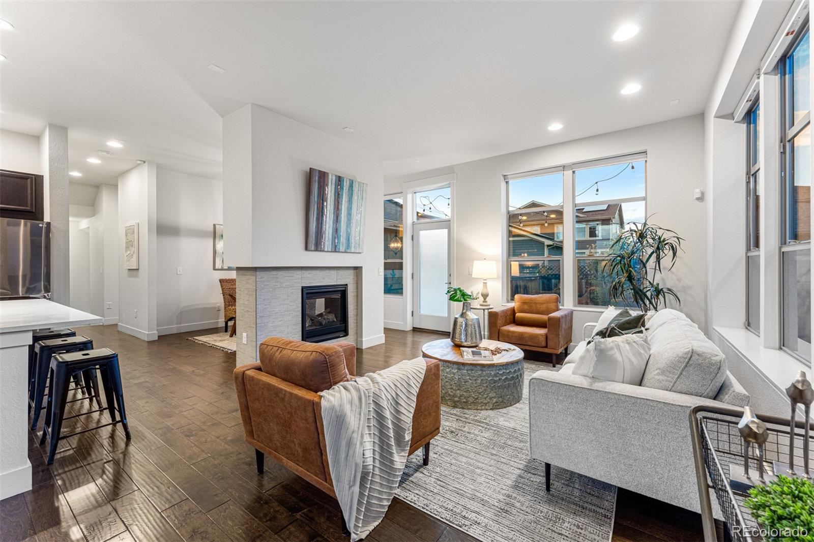 a living room with furniture fireplace and a large window