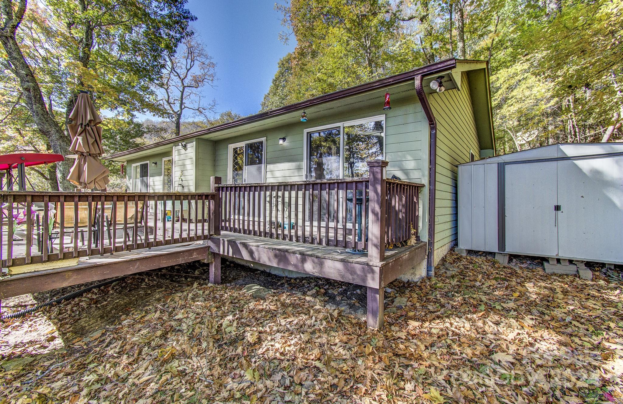 a view of a deck with a small yard and wooden fence