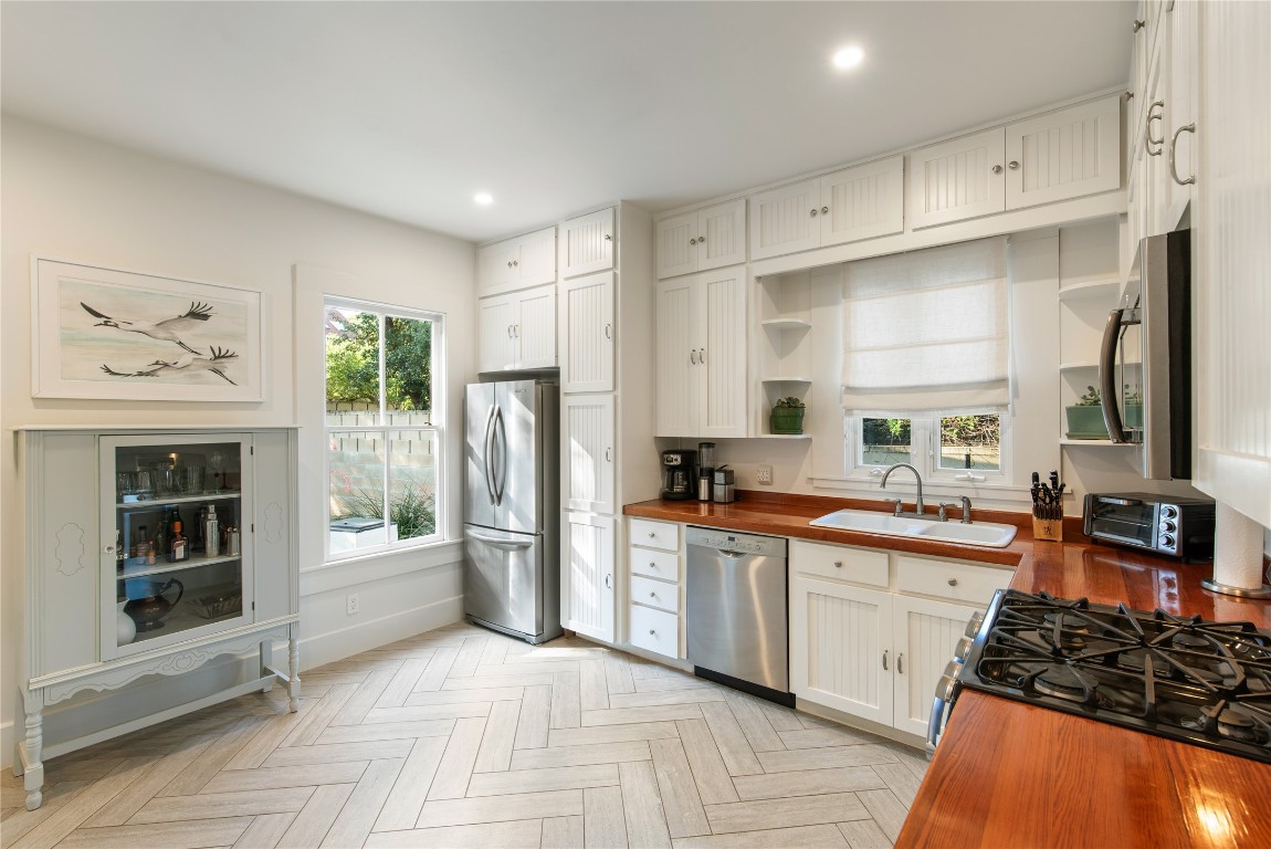 a large kitchen with stainless steel appliances lots of counter space and wooden floor