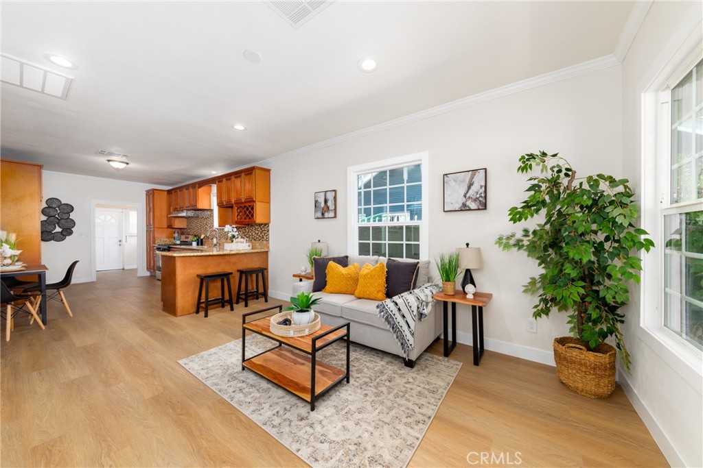 a living room with furniture kitchen view and a large window