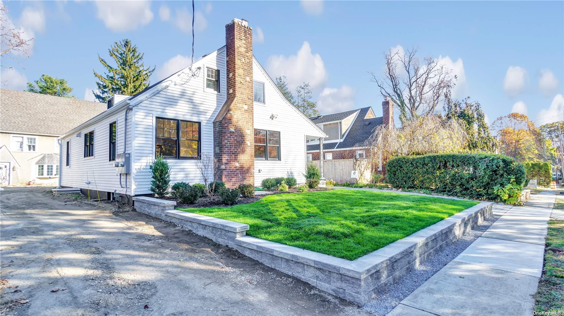 a front view of a house with a yard and potted plants