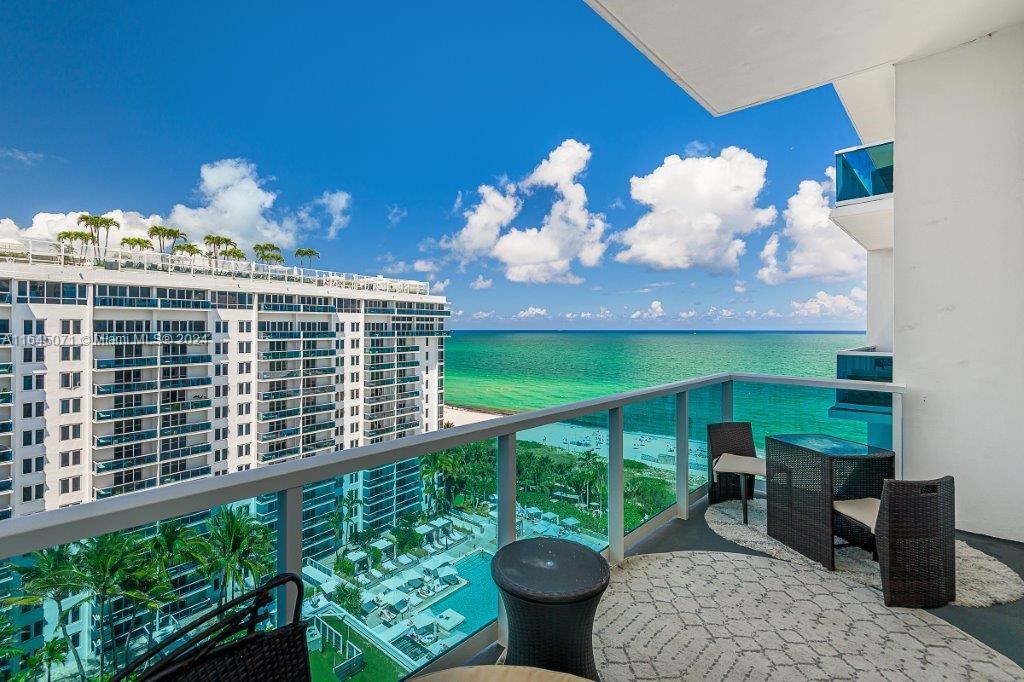 a view of a balcony with dining space and garden view