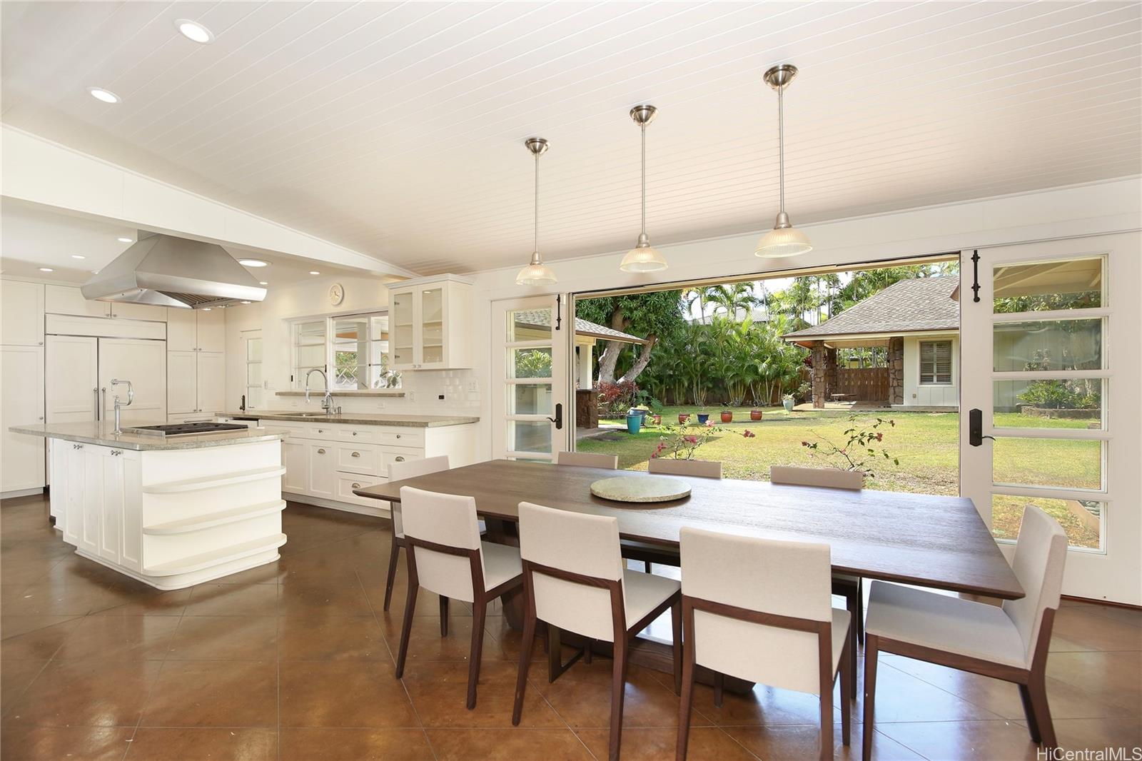 a view of a dining room and livingroom with furniture wooden floor a chandelier